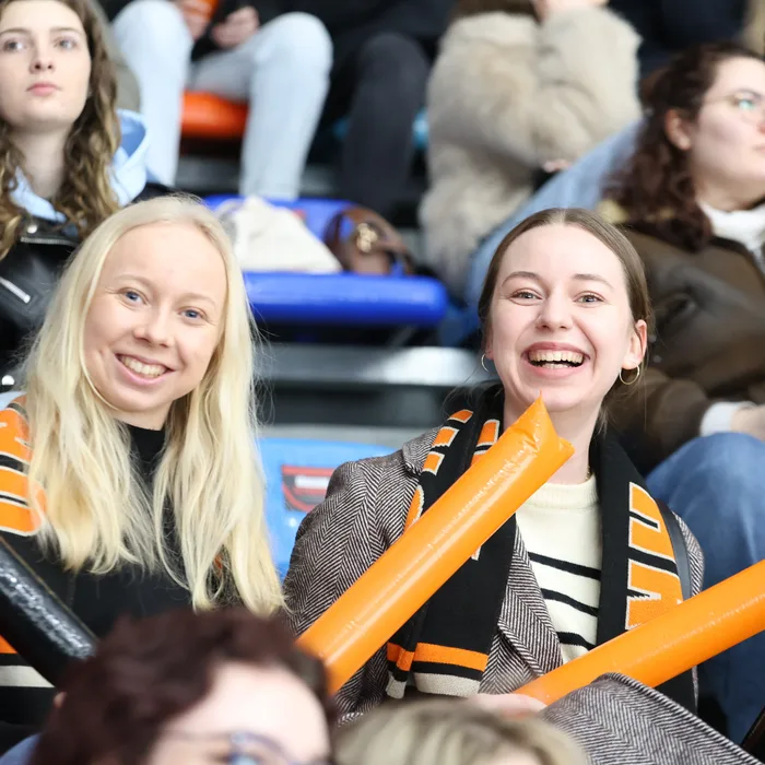 Fanoušci UNIted HK s oranžovými nafukovacími tyčemi na tribuně