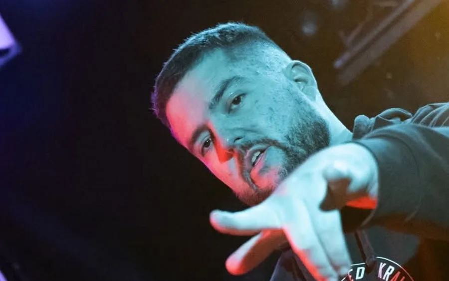 Člen Infinity Vibes DJ v nášivce UNIted HK gestikuluje do publika